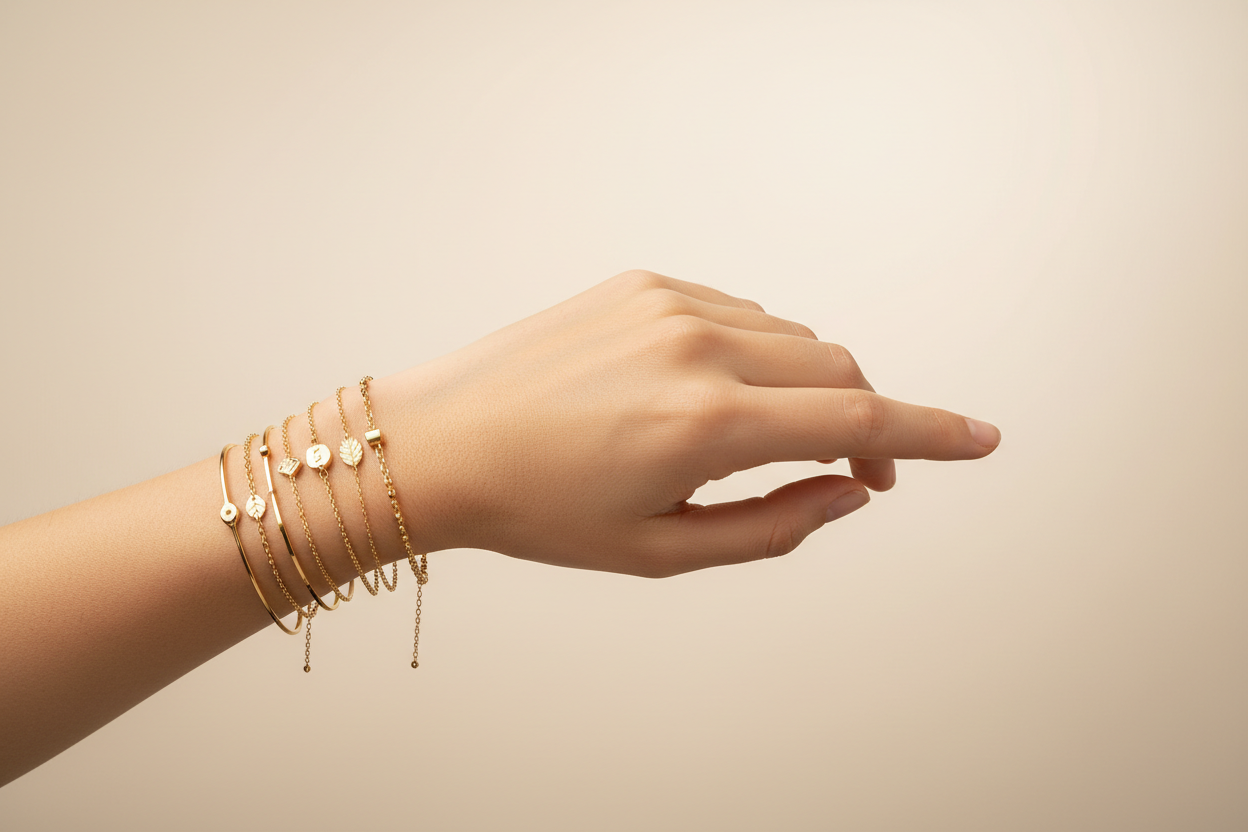 Genera la imagen de una mujer con la muñeca con pulseras de oro, elegantes y finas, en formato banner.